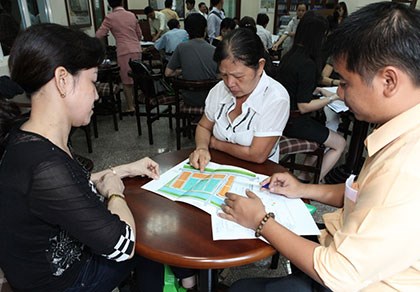 Các chuyên viên tư vấn cho khách hàng mua nhà tại một dự án. Ảnh: YÊN TRANG