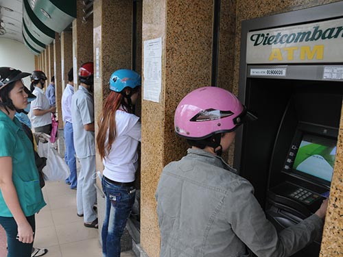 Chủ thẻ phải trả đủ loại phí khi giao dịch trên máy ATM Ảnh: HỒNG THÚY