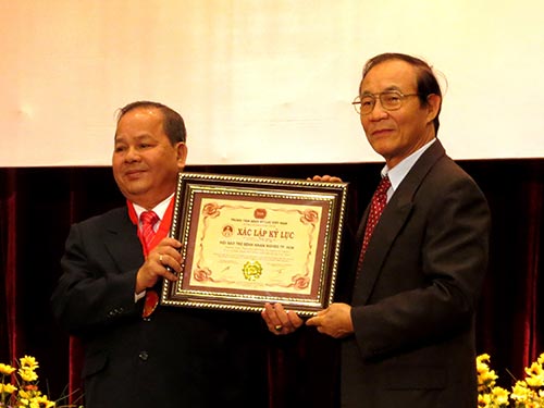 Ông Trần Hữu Tâm, Phó Chủ tịch Hội Bảo trợ bệnh nhân nghèo TP HCM (trái), thay mặt hội đón nhận 
Kỷ lục Guinness Việt Nam về số ca phẫu thuật mắt miễn phí