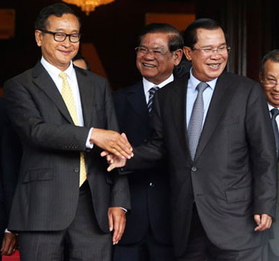 Thủ tướng Campuchia Hun Sen (phải) bắt tay ông Sam Rainsy sau cuộc gặp hôm 22-7 Ảnh: REUTERS