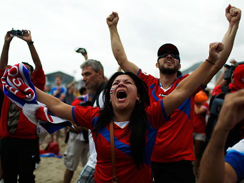 Xem truyền hình trực tiếp tại bãi biển ở Rio de Janeiro, CĐV Costa Rica phấn khích sau chiến thắng 1-0 của đội nhà trước Ý Ảnh: REUTERS