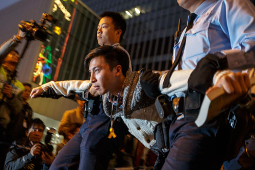 Cảnh sát bắt một người không chịu rời khỏi địa điểm biểu tình ở khu Kim Chung hôm 11-12 Ảnh: REUTERS