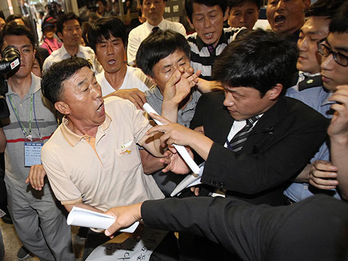 Người thân nạn nhân xô xát với nhân viên an ninh bên ngoài phiên tòa Ảnh: REUTERS