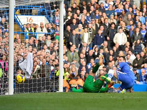 Sức ép của Terry (phải) khiến thủ môn Howard phạm sai lầm, giúp Chelsea giành chiến thắng ở phút bù giờ   Ảnh: REUTERS