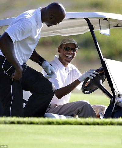 Tổng thống Mỹ Barack Obama (phải) chơi golf cùng cựu ngôi sao bóng rổ Alonzo Mourning Ảnh: AP