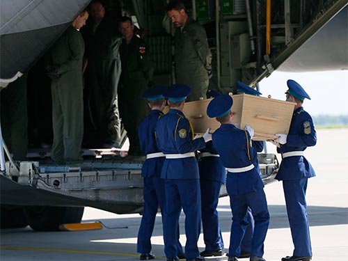 Đội quân danh dự Ukraine đưa quan tài của các nạn nhân MH17 lên máy bay tới Hà Lan hôm 23-7  Ảnh: REUTERS