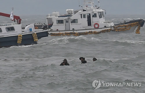 Thợ lặn chiến đấu với sóng cao để vào trong xác tàu Sewol. Ảnh: Yonhap
