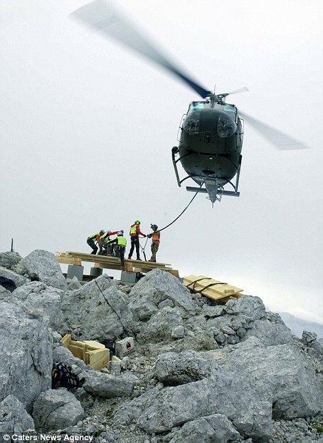 Trực thăng vận chuyển gỗ và thép lên đỉnh núi cao 2.530 m. Ảnh: Caters News Agency