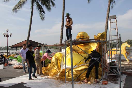 Các công nhân đang hoàn thiện bức tượng Phật Di Lặc