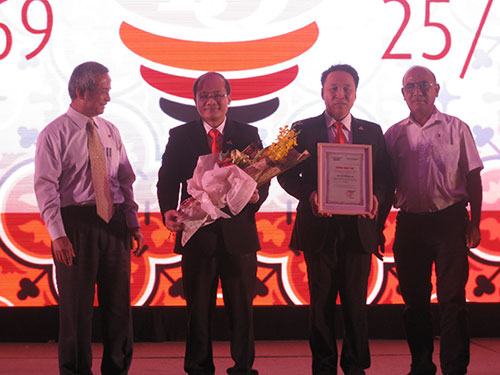 Ông Đặng Ngọc Tùng - Ủy viên Trung ương Đảng, Chủ tịch Tổng LĐLĐ Việt Nam (bìa trái) - tặng hoa cho đại diện Công ty CP Đồng Tâm vì đã đóng góp cho chương trình “Tấm lưới nghĩa tình vì ngư dân Hoàng Sa - Trường Sa”