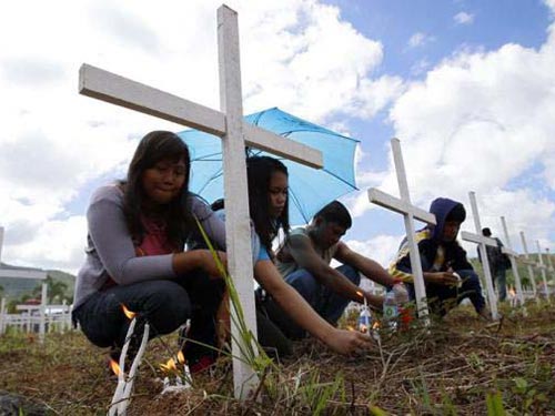 Người dân Tacloban trước ngôi mộ tập thể hôm 8-11 Ảnh: Reuters