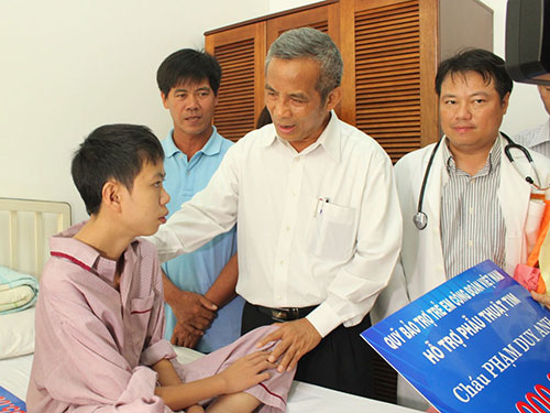 Ông Đặng Ngọc Tùng, Chủ tịch Tổng LĐLĐ Việt Nam, trao tiền hỗ trợ cháu Phạm Duy Anh