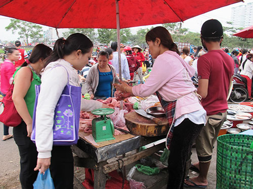 Thu nhập bấp bênh buộc công nhân phải dè sẻn trong chi tiêu. Trong ảnh: Công nhân Công ty Pou Yuen (quận Bình Tân, TP HCM) đang mua thực phẩm ở khu chợ tạm gần công ty Ảnh: HỒNG NHUNG