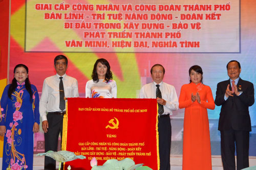 Ông Lê Thanh Hải (bìa phải) - Ủy viên Bộ Chính trị, Bí thư Thành ủy TP HCM - trao bức trướng cho lãnh đạo LĐLĐ TP tại lễ kỷ niệm      Ảnh: TẤN THẠNH