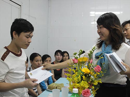 Bà Hồ Bích Ngọc - Chủ tịch LĐLĐ quận 1, TP HCM - tặng quà cho công nhân Công ty CP Thực phẩm 
Trung Sơn không có điều kiện về quê đón Tết  Ảnh: NGÂN HÀ
