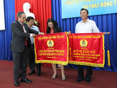 Ông Nguyễn Hòa, Chủ tịch LĐLĐ tỉnh Khánh Hòa, trao cờ thi đua 
của Tổng LĐLĐ Việt Nam cho cá nhân, tập thể xuất sắc