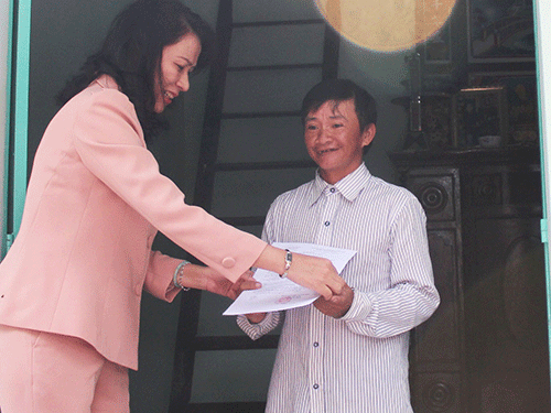 Bà Nguyễn Thị Thu, Chủ tịch LĐLĐ TP HCM, trao quyết định tặng nhà cho anh Nguyễn Văn Chính