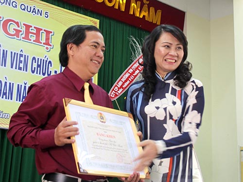 Bà Nguyễn Thị Thu, Chủ tịch LĐLĐ TP HCM, trao bằng khen của Tổng LĐLĐ Việt Nam cho CĐ Giáo dục quận 5 Ảnh: HỒNG ĐÀO