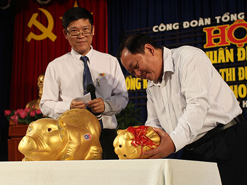 Ông Đỗ Văn Thành, Chủ tịch CĐ Tổng Công ty Công nghiệp Sài Gòn (bìa phải), khui heo đất