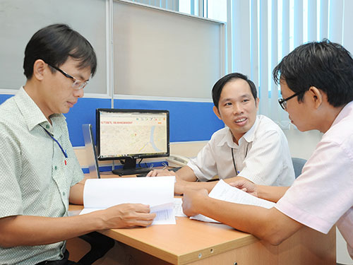 Anh Lê Thanh Quang (giữa) trao đổi công việc với đồng nghiệp