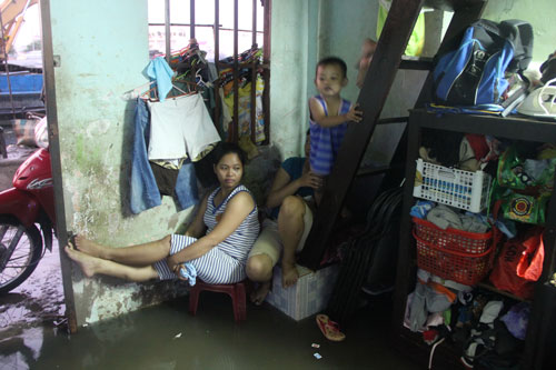 Nước tràn vào nhà dân ở đường Nguyễn Ngọc Cung (quận 8) Ảnh: LƯƠNG SƠN