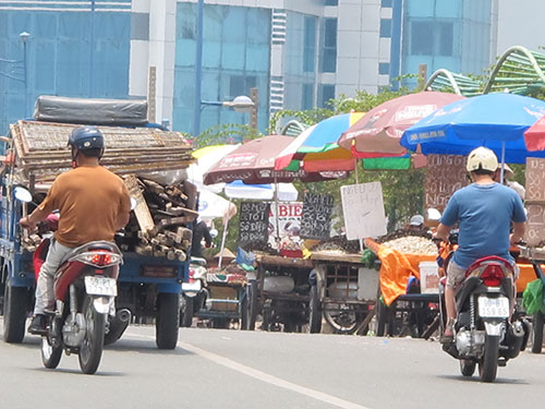 Xe thô sơ, tự chế bán hải sản đậu dày đặc trên cầu Tham Lương, quận 12, TP HCM Ảnh: PHẠM DŨNG