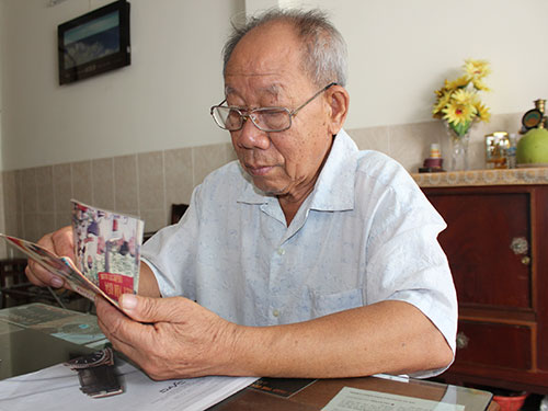 Ông Trần Bảo Thạnh xem lại những tấm hình Trung đội E khi có dịp về Cao Lãnh, tỉnh Đồng Tháp