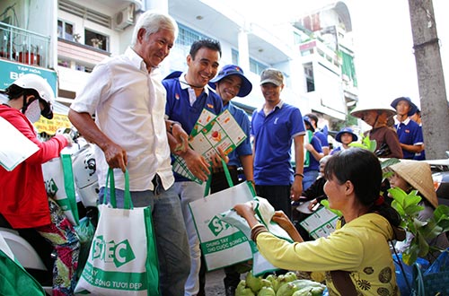 Đại sứ chương trình Quyền Linh đang phát tờ rơi và túi sinh học cho người dân