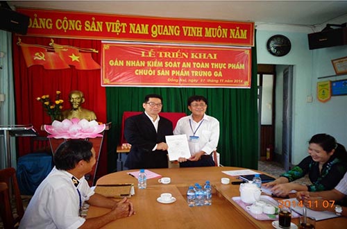 Ông Nguyễn Hữu Danh (áo trắng), đại diện Chi cục Quản lý chất lượng nông lâm sản và thủy sản Đồng Nai, trao giấy xác nhận “Sản phẩm được kiểm soát an toàn thực phẩm theo chuỗi” cho ông Thunya Wealuvan, Giám đốc ngành trứng gia cầm CP Việt Nam