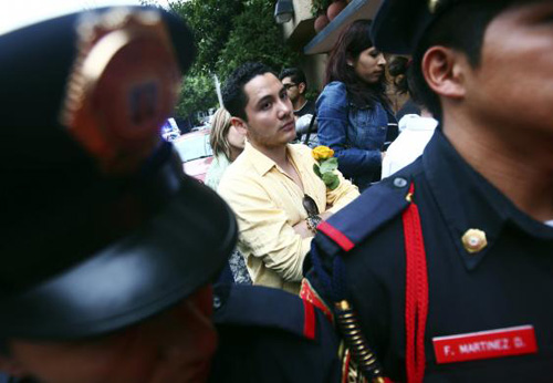 Người thanh niên cầm hoa vàng đứng trước cửa nhà Gabriel Garcia Marquez trong ngày ông qua đời. Ảnh: Reuters