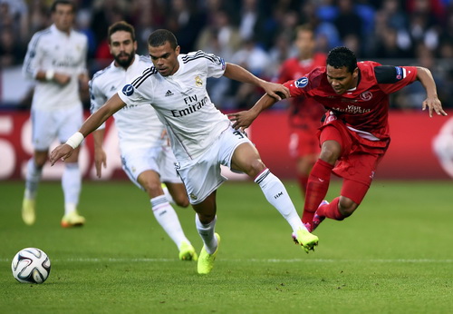 Pepe tranh chấp bóng cùng Carlos Bacca (phải, Sevilla)