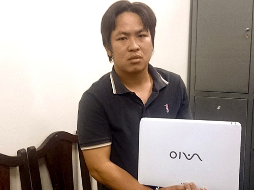 Nguyễn Đình Phòng sau khi bị bắt giữ tại cơ quan công an cùng tang vật là chiếc máy tính hiệu Vaio