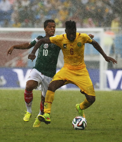 Cameroon (Alex Song - áo vàng) gặp khó khăn trước lối chơi chặt chẽ của Mexico