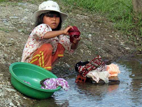 Nhiều trẻ phải mang quần áo ra suối giặt giũ phụ giúp gia đình vì cha mẹ, anh chị bận rộn mưu sinh hằng ngày