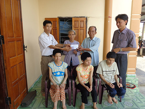 Ông Phan Thành Phương, Phó Bí thư Đảng ủy xã Hiền Ninh (bên trái), thay mặt Báo Người Lao Động trao tiền ủng hộ của bạn đọc cho gia đình ông Nguyễn Hữu Vi