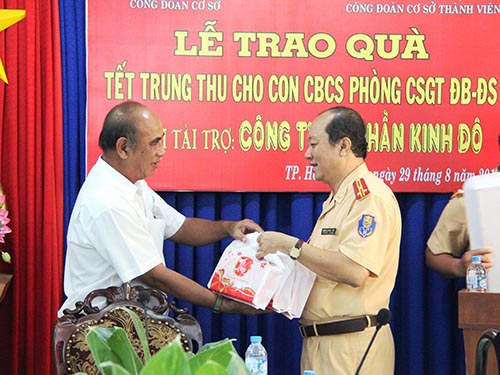 Đại diện Báo Người Lao Động trao quà cho lãnh đạo Phòng CSGT Đường bộ - Đường sắt Công an TP HCM