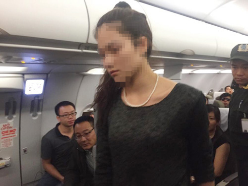 Một trong 2 nữ hành khách gây rối trên máy bay được lực lượng an ninh đưa xuống khỏi máy bay Vietnam Airlines - Ảnh: Long Nga