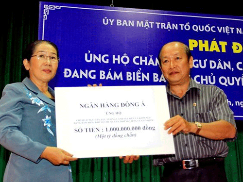 Ông Nguyễn Thanh Hùng, Phó Bí thư thường trực Đảng ủy DongA Bank (bên phải) trao 1 tỉ đồng cho đại diện UBMTTQ TPHCM