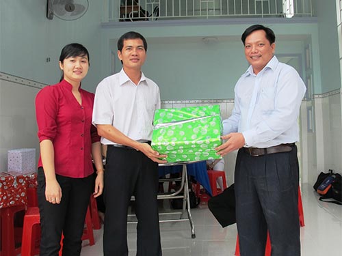 Ông Phạm Tấn Phước - Chủ tịch Công đoàn Giáo dục huyện Nhà Bè, TP HCM (phải) - trao quà cho giáo viên khó khăn