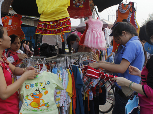 Công nhân tranh thủ mua quần áo giảm giá làm quà cho người nhà ở quê tại một chợ tạm trong Khu công nghiệp Đồng An (Bình Dương) - Ảnh: Nguyễn Trí