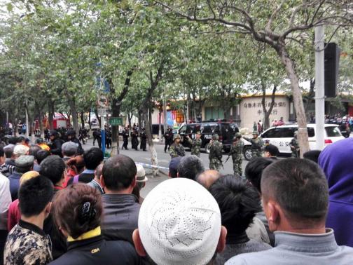 People look on at a street cordoned off by police after a blast in Urumqi, Xinjiang Uyghur Autonomous Region May 22, 2014. REUTERS-CNSphoto