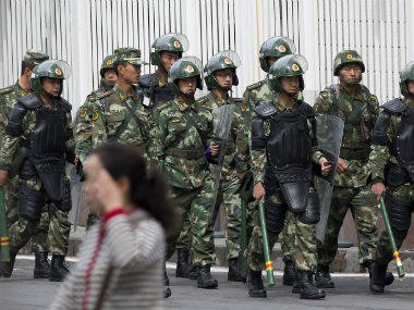 Paramilitary policemen with shields and batons patrol near the Peoples Square in Urumqi, Chinas northwestern region of Xinjiang. AP 