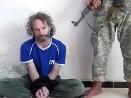 In this image made from undated video obtained by The Associated Press, a man believed to be Peter Theo Curtis, a U.S. citizen held hostage by an al-Qaida linked group in Syria, delivers a statement.