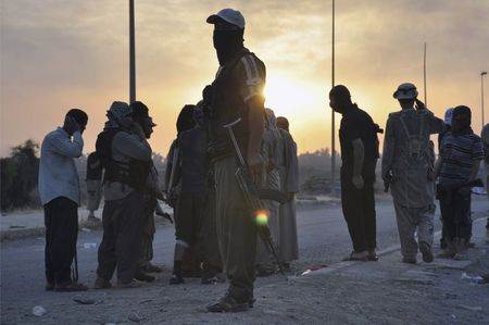 File photo of fighters of the Islamic State of Iraq and the Levant (ISIL) standing guard at a checkpoint in the northern Iraq city of Mosul