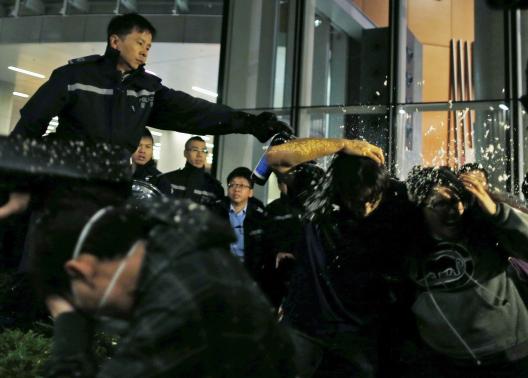 Pro-democracy protesters are pepper sprayed by a policeman as they try to break into the Legislative Council in Hong Kong early November 19, 2014, in response to an earlier clear up by bailiffs on part of the Occupy Central protest site.   REUTERS-Tyrone Siu