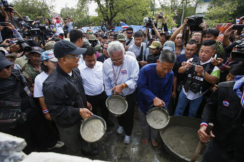 Ông Suthep đổ xi-măng xây tường chắn. Ảnh: Reuters