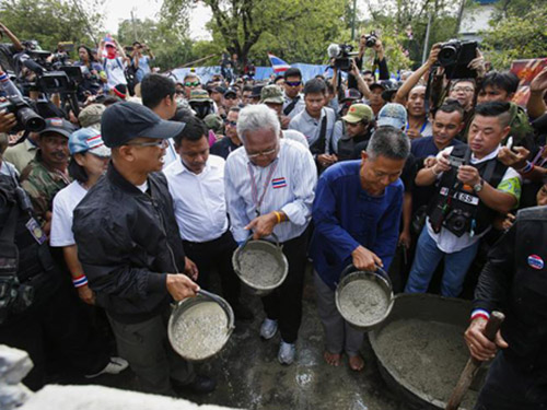 Ông Suthep Thaugsuban cùng người biểu tình đổ xi-măng xây tường chắn cửa tòa nhà chính phủ
Ảnh: Reuters