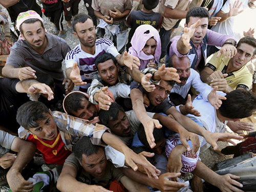 Người Yazidi nhận hàng cứu trợ gần biên giới Iraq - SyriaẢnh: AP