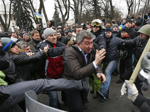 Người biểu tình tấn công nghị sĩ Vitaly Grushevsky thuộc Đảng Các khu vực bên ngoài trụ sở Quốc hội Ukraine ngày 22-2Ảnh: REUTERS