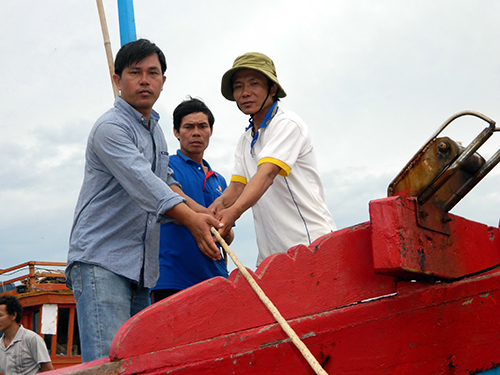 Thuyền trưởng Nguyễn Xu (giữa) cùng các ngư dân sau chuyến biển cứu 17 ngư dân gặp nạn